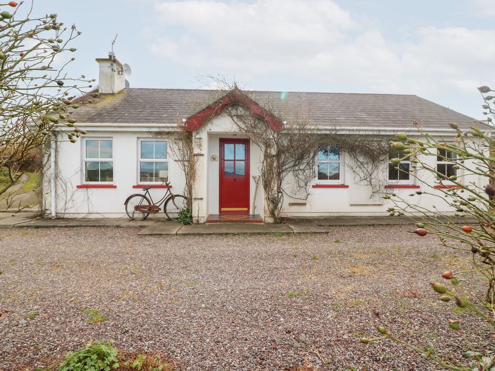 A cottage with a red door and gravel driveway at Herons Cove Cottage Ballydehop