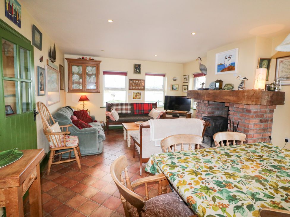 A living room with a sofa and dining table at Herons Cove Cottage in Ballydehop