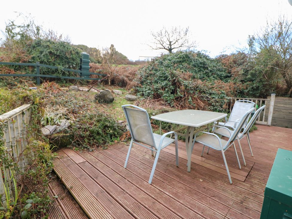 A garden with a table and chairs at Herons Cove Cottage Ballydehop