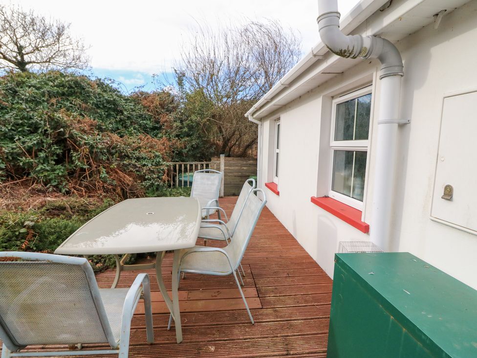 An outdoor seating area with a table and chairs at Herons Cove Cottage Ballydehop