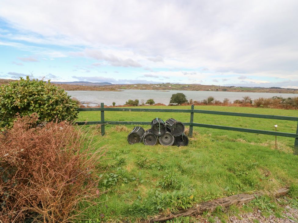 A view of grass and a fence with buckets at Herons Cove Cottage in Ballydehop