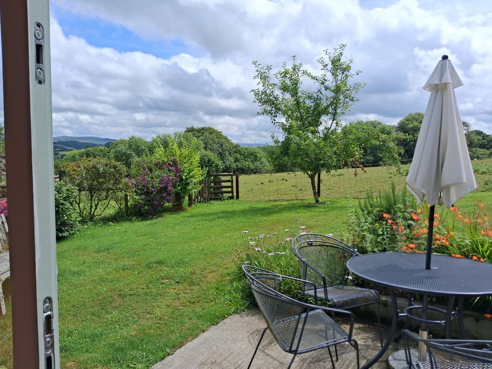 A garden with a table and chairs at Woodstone Barn Whitchurch near Tavistock
