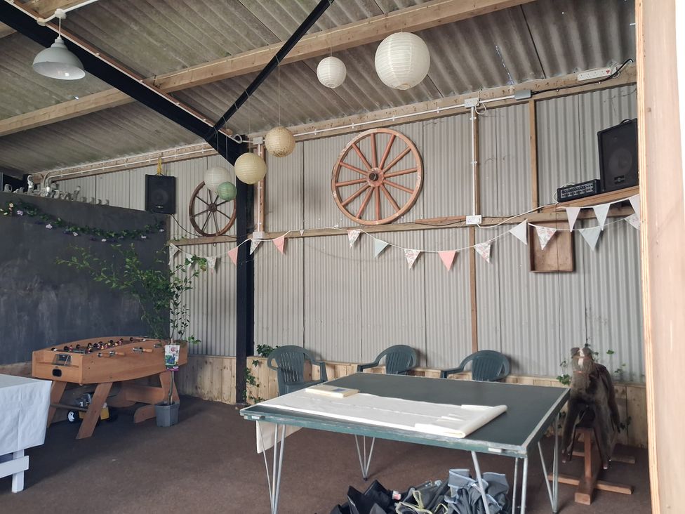An indoor space with a foosball table and chairs at Woodstone Barn Whitchurch near Tavistock
