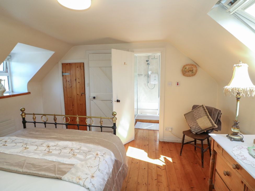 A bedroom with a bed and a shower at Fuschia Cottage, Waterville, County Kerry
