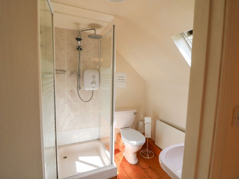 A bathroom with a shower and toilet at Fuschia Cottage in Waterville, County Kerry