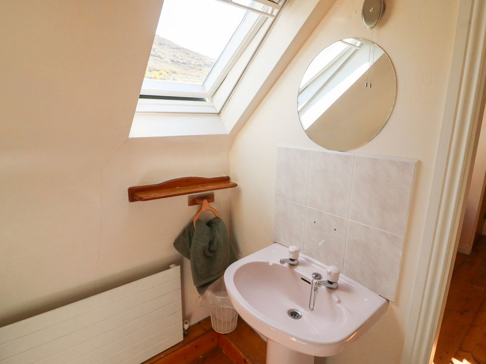 A bathroom with sink and mirror at Fuschia Cottage in Waterville, County Kerry