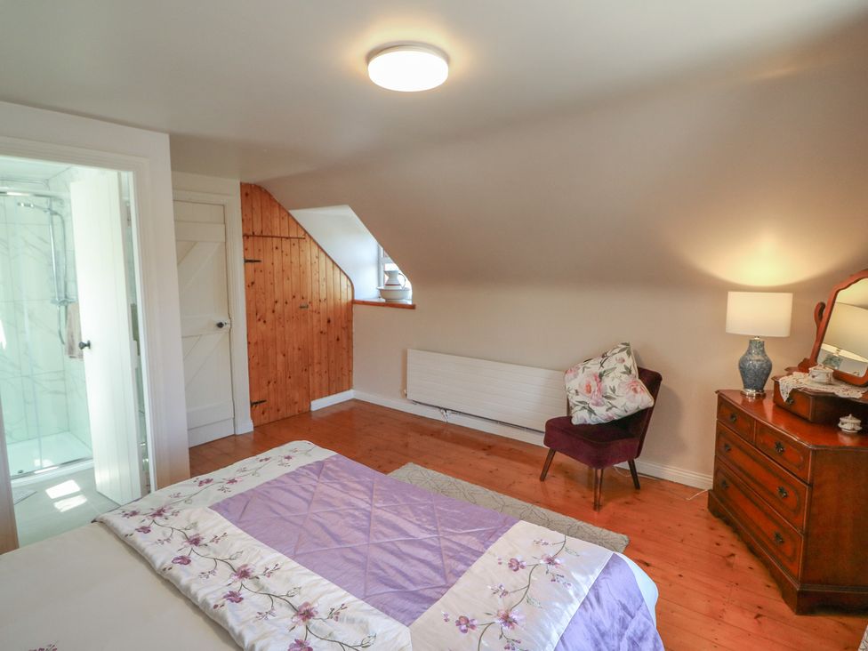 A bedroom with a bed and bathroom in Fuschia Cottage Waterville, County Kerry