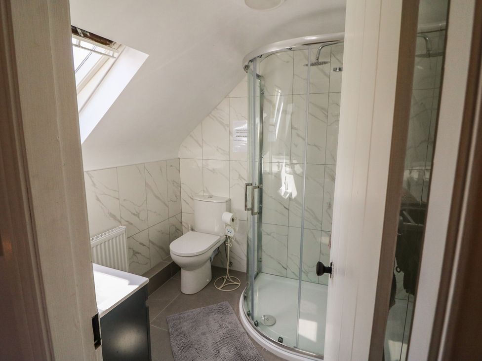 A bathroom with a shower and toilet at Fuschia Cottage Waterville, County Kerry