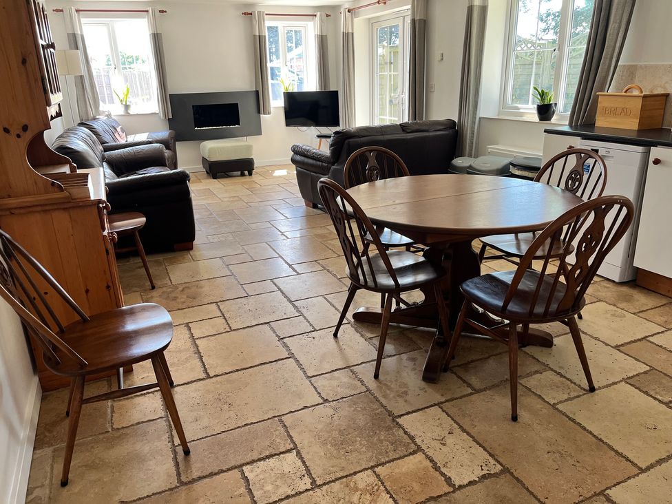A living room with a sofa and dining table at Mill Lodge in Brisley