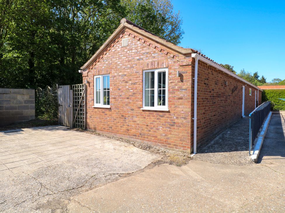 An outdoor view of a brick building with a gate at Mill Lodge Brisley