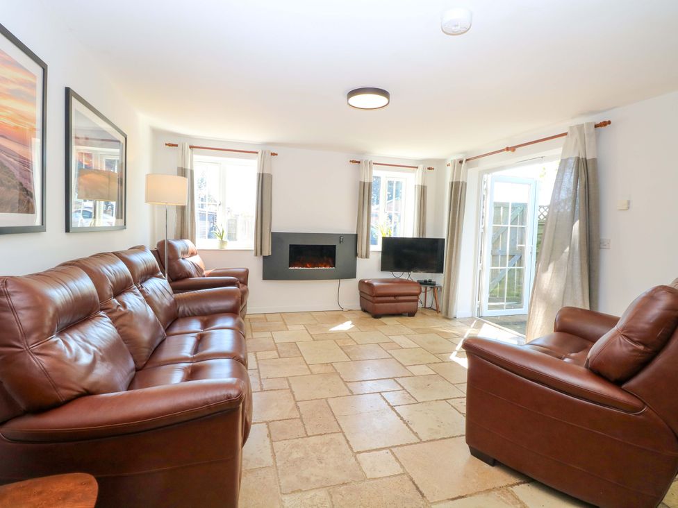 A living room with a sofa and a television at Mill Lodge in Brisley