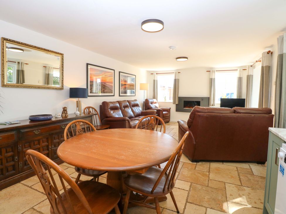 A living room with a dining table and sofa at Mill Lodge in Brisley
