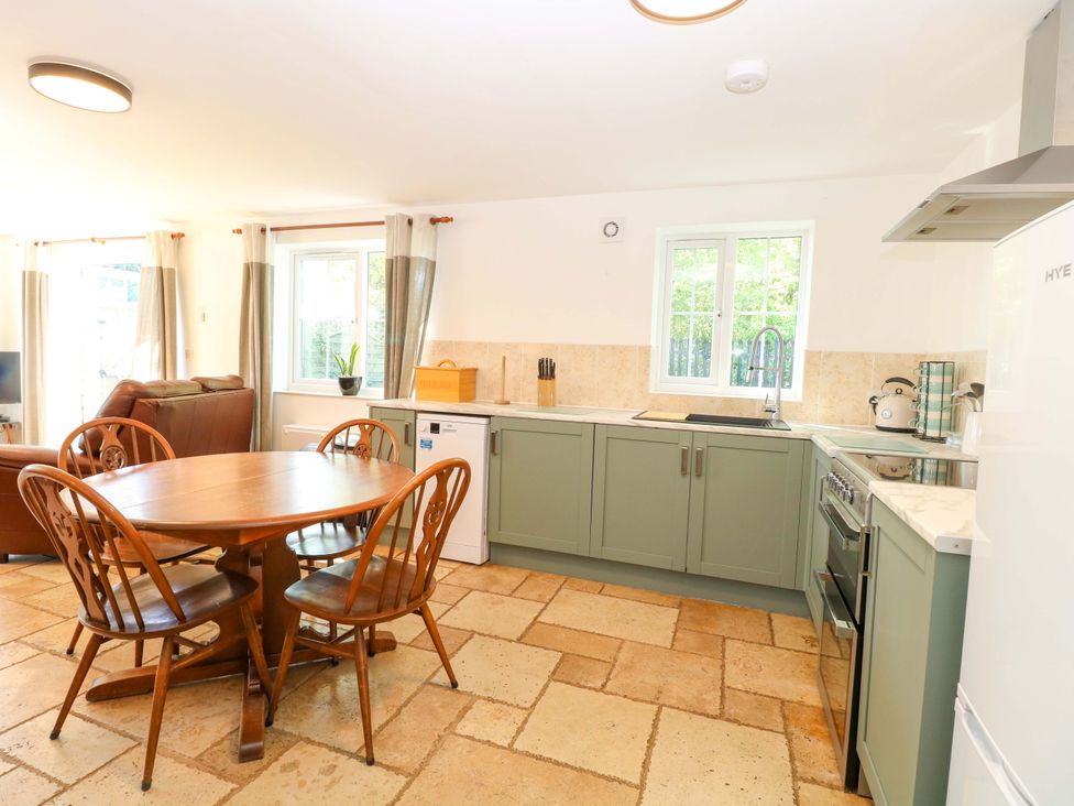 A kitchen with a dining table and chairs at Mill Lodge in Brisley