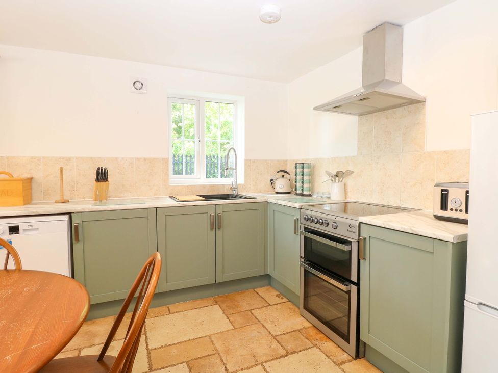 A kitchen with appliances and a table at Mill Lodge in Brisley