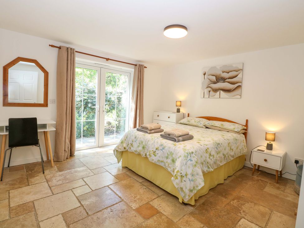 A bedroom with a bed, bedside tables, and a chair at Mill Lodge in Brisley