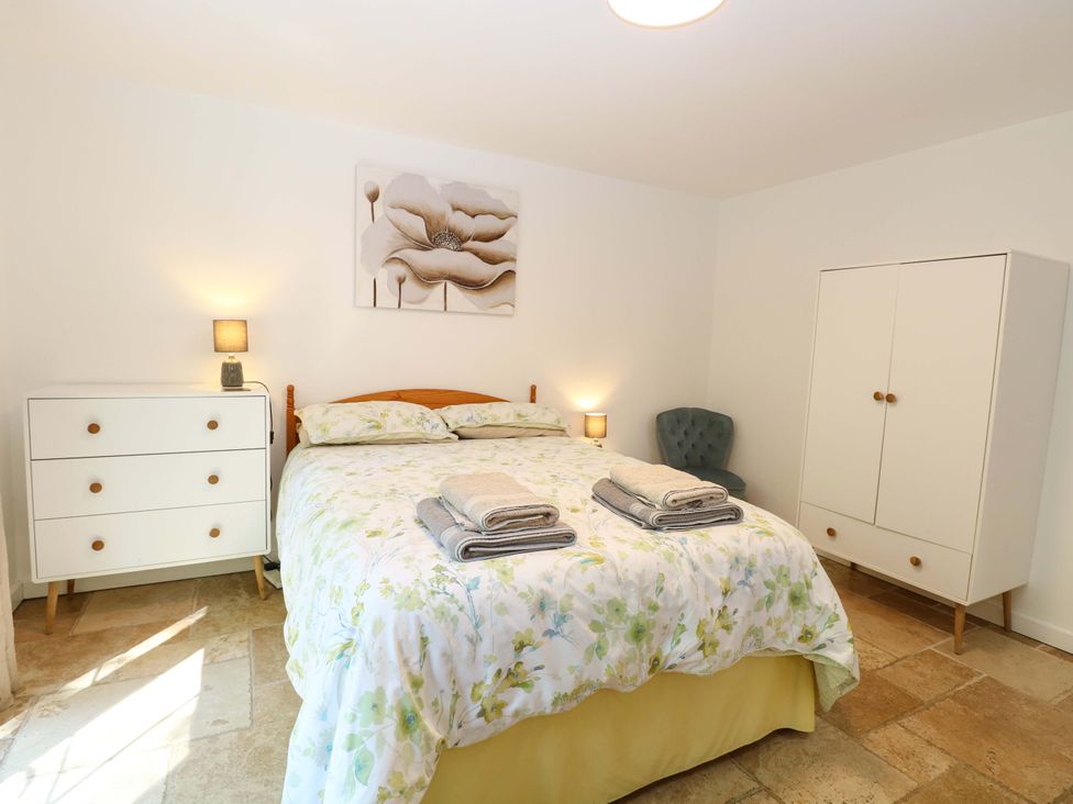 A bedroom with a bed and dresser at Mill Lodge in Brisley