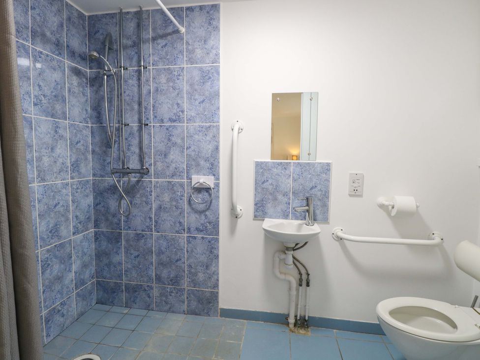 A bathroom with a shower, sink, and toilet at Mill Lodge in Brisley