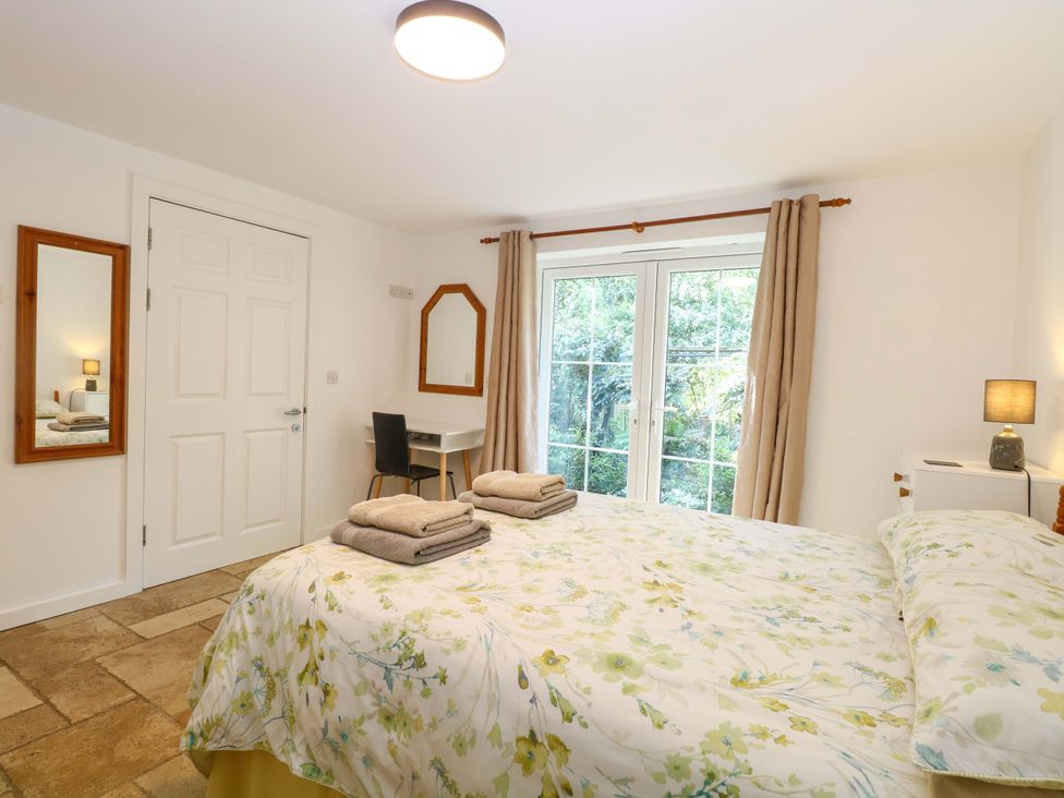 A bedroom with a bed and a desk at Mill Lodge Brisley