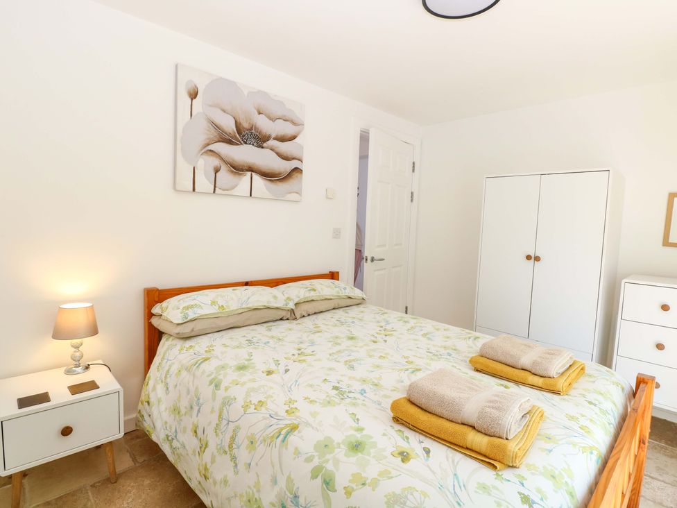 A bedroom with a bed, nightstand, and dresser at Mill Lodge in Brisley