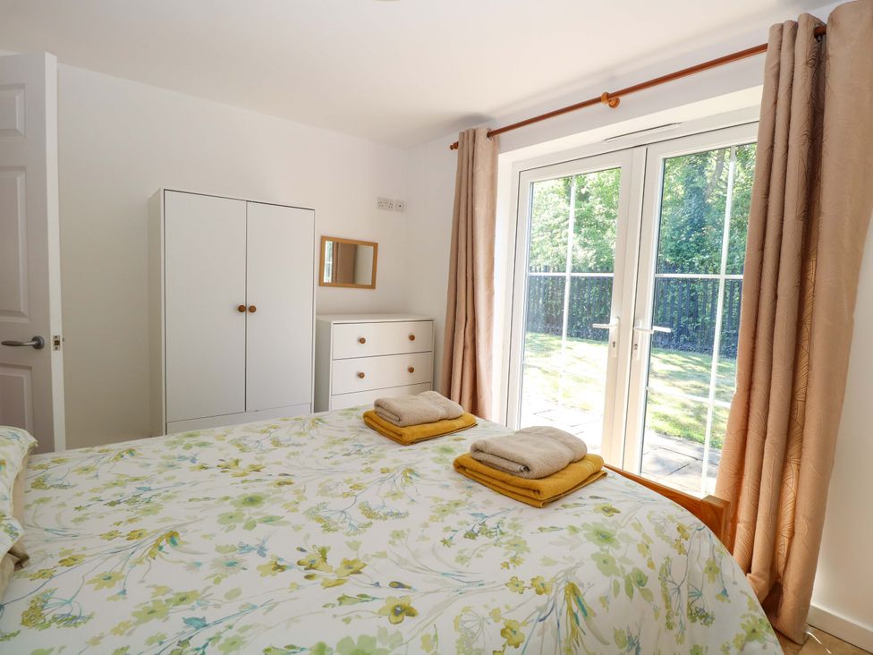 A bedroom with a bed and wardrobe at Mill Lodge in Brisley