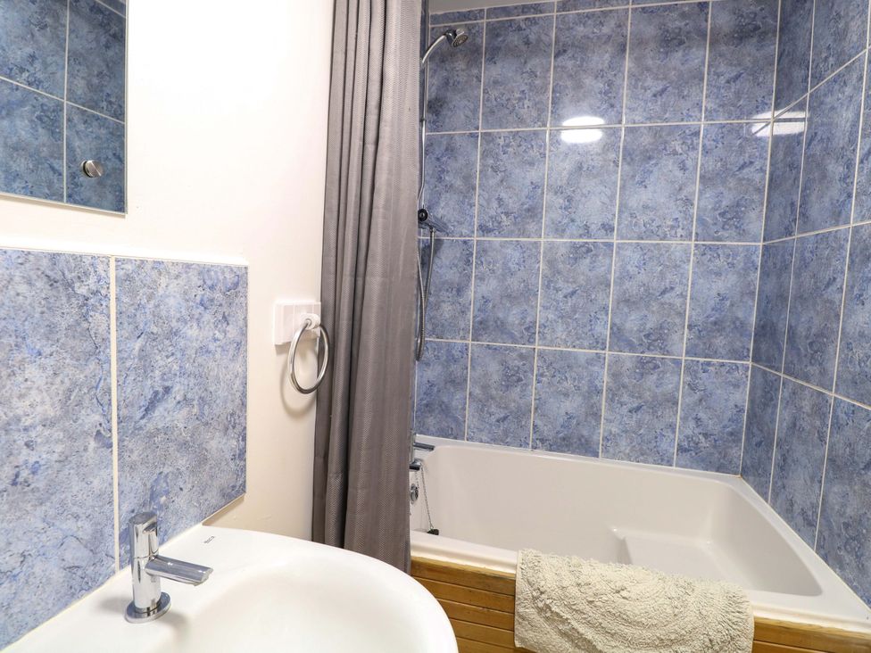 A bathroom with a bathtub and sink at Mill Lodge in Brisley