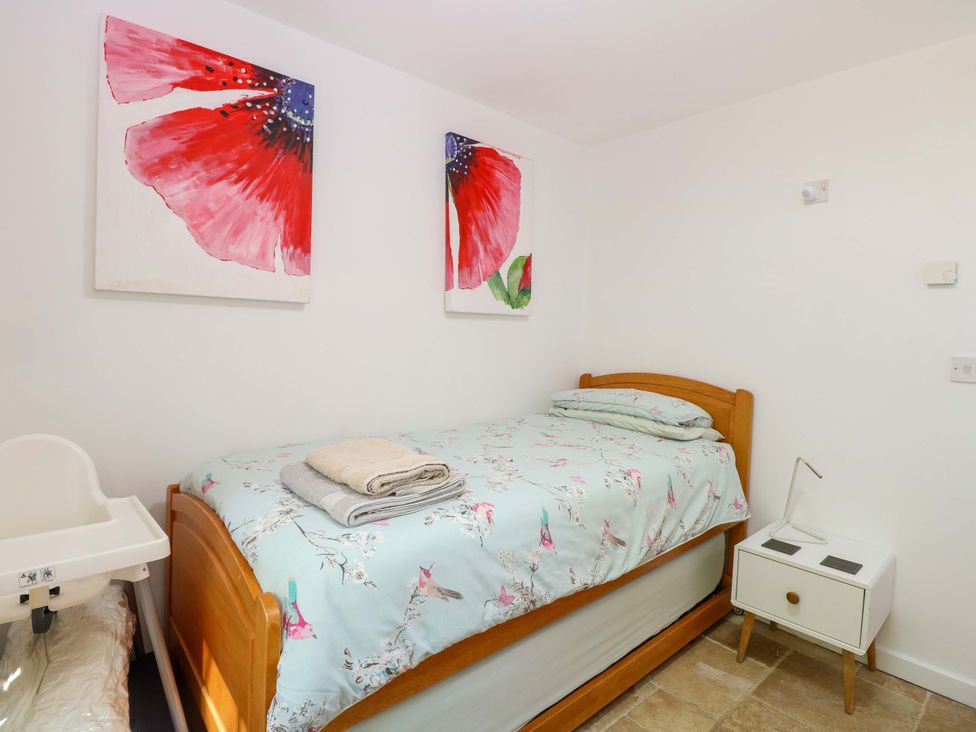 A bedroom with a single bed and artwork on the wall at Mill Lodge Brisley
