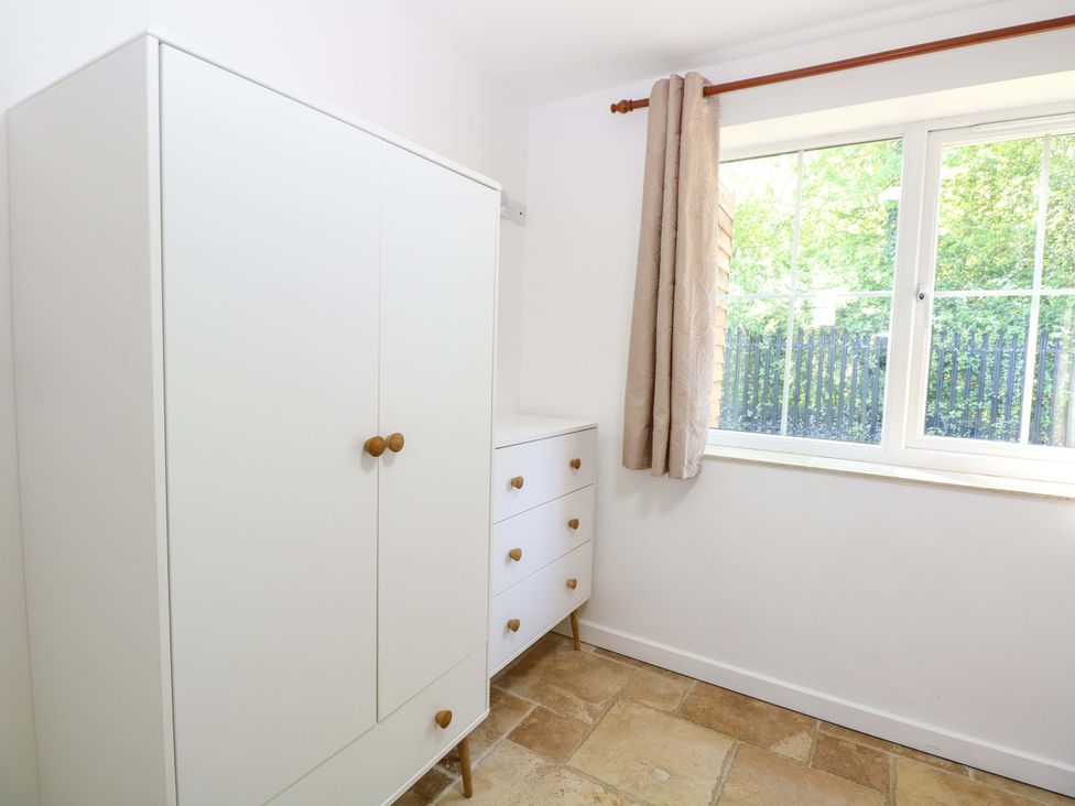 A bedroom with a wardrobe and a chest of drawers at Mill Lodge in Brisley