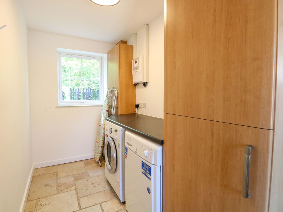 A laundry room with a washing machine and countertop at Mill Lodge in Brisley