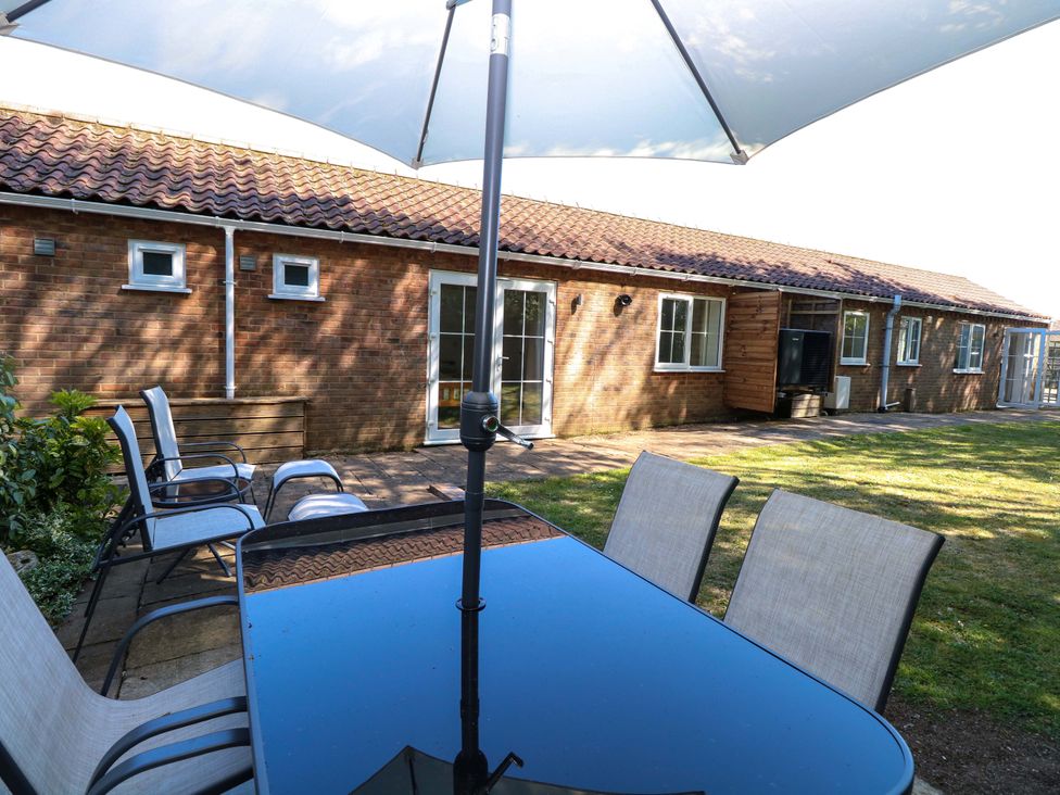 A garden with a table and chairs at Mill Lodge in Brisley