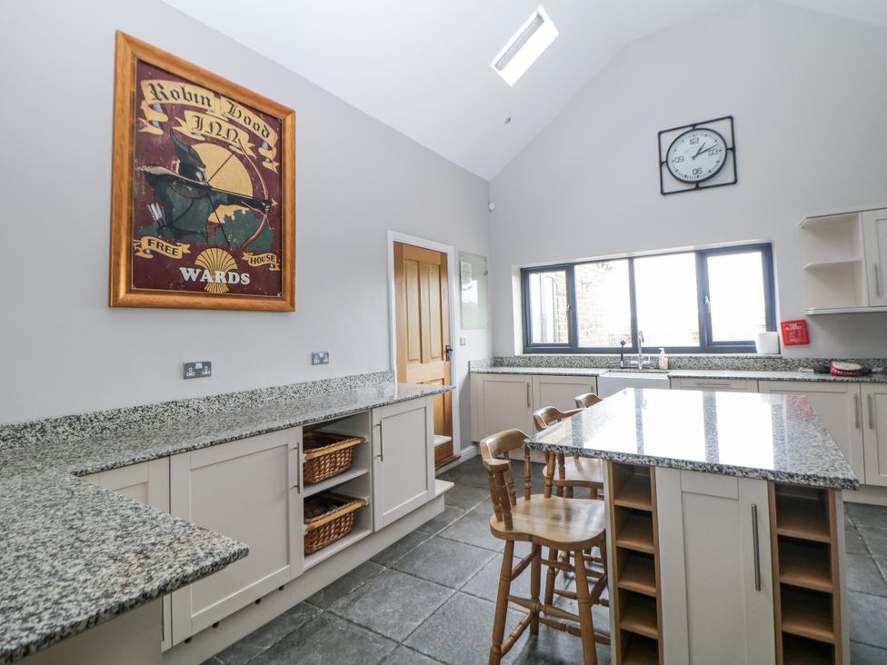 A kitchen with a countertop and bar stools at The Old Robin Hood in Holmesfield near Bakewell