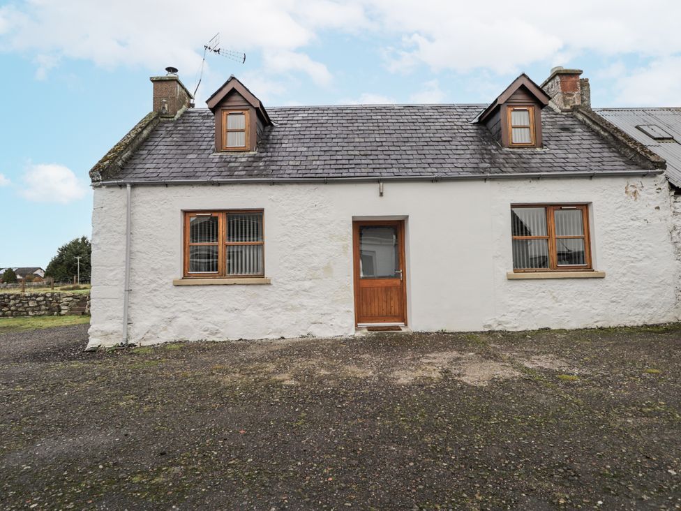 A house with symmetrical windows and a central door at The Croft House in Muir of Ord near Beauly