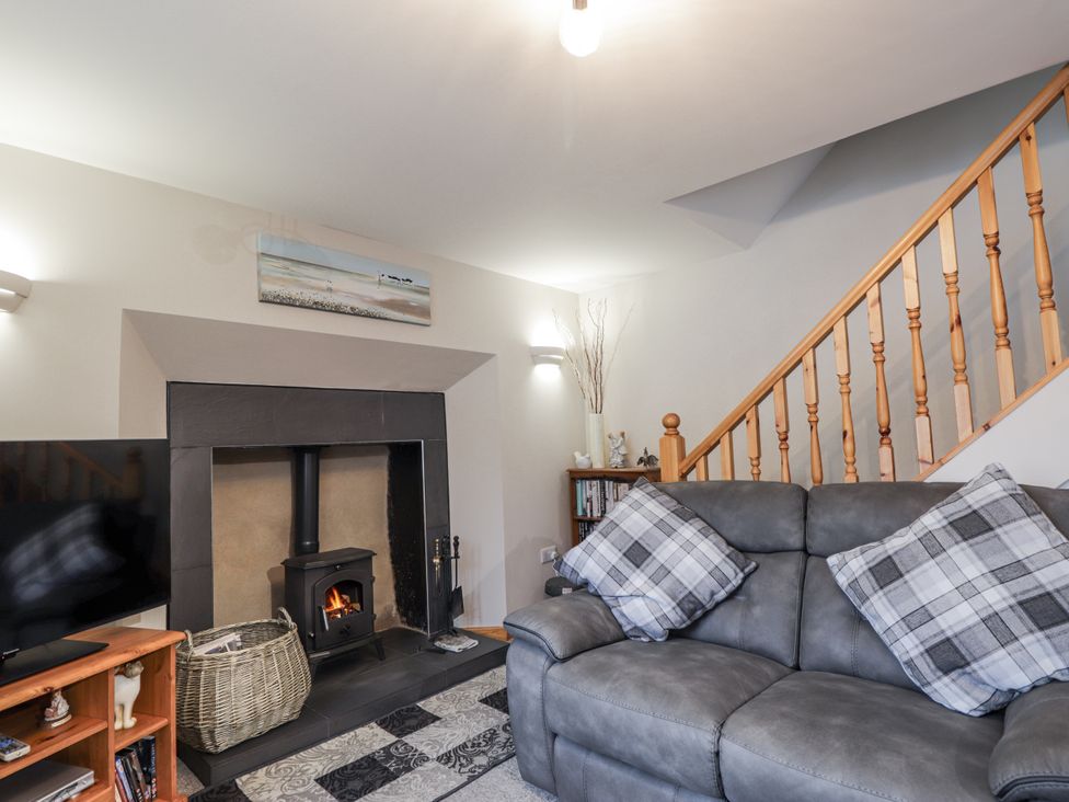 A living room with a television and fireplace at The Croft House in Muir of Ord near Beauly