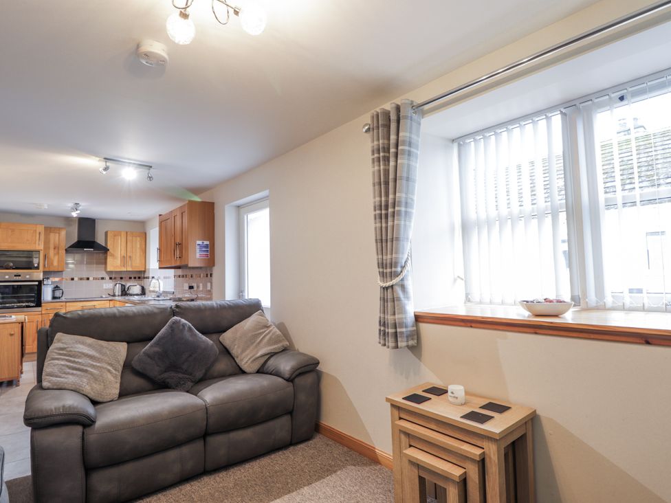 A living room with a sofa and table at The Croft House in Muir of Ord near Beauly