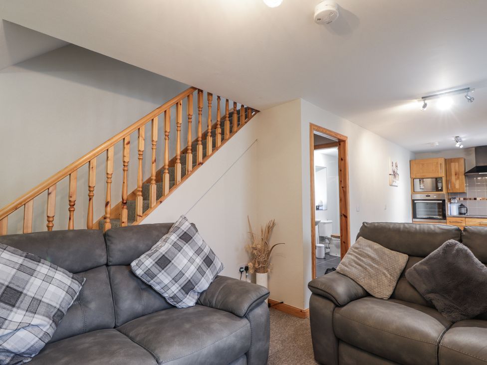 A living room with a staircase leading upstairs at The Croft House in Muir of Ord near Beauly