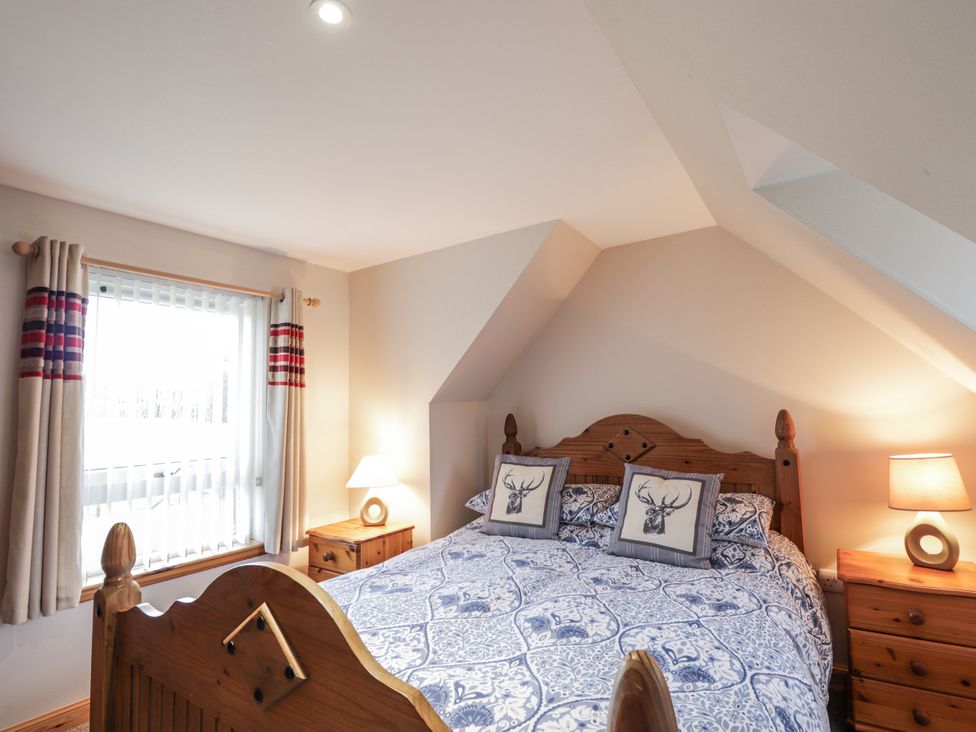 A bedroom with a bed and bedside table at The Croft House in Muir of Ord near Beauly