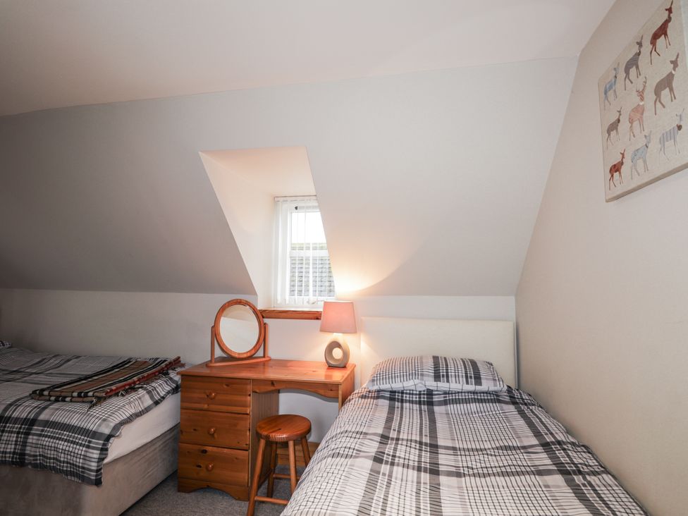 A bedroom with beds and a desk at The Croft House in Muir of Ord near Beauly