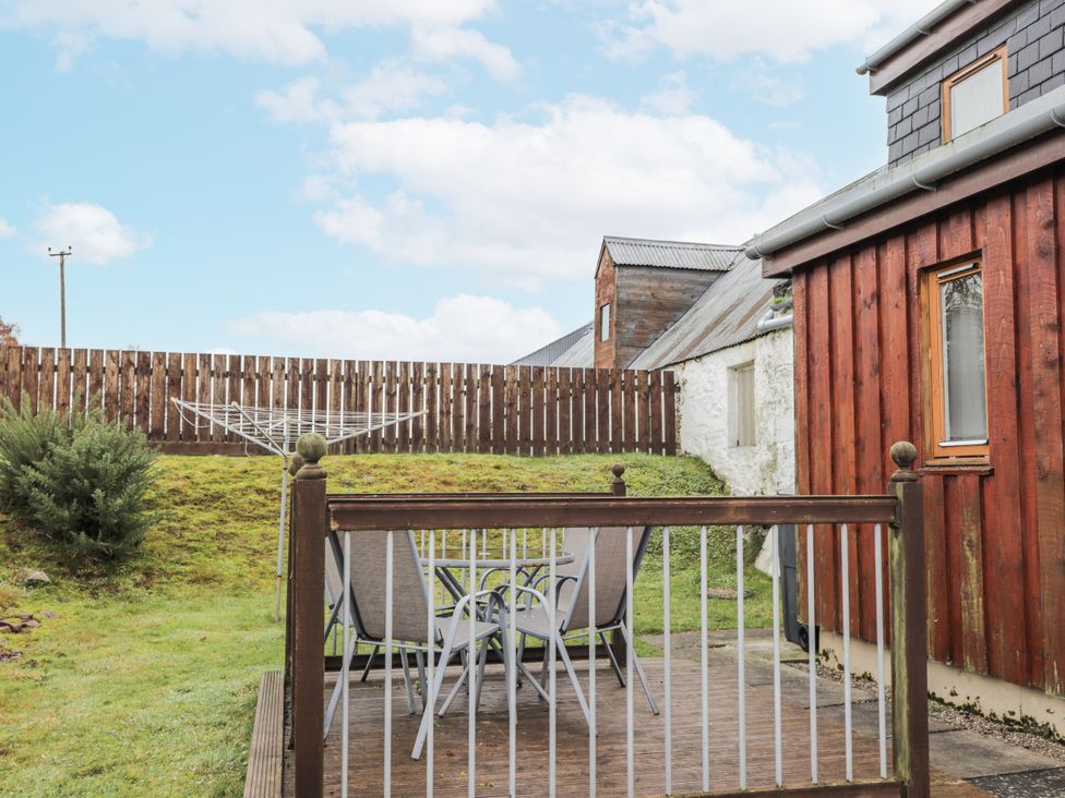 An outdoor area with a table and chairs at The Croft House in Muir of Ord near Beauly