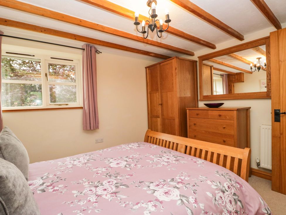A bedroom with a bed and wardrobe at Copper Beech Cottage in Torver