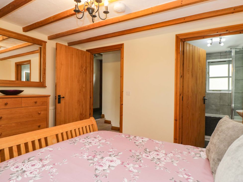 A bedroom with a bed and dresser at Copper Beech Cottage Torver