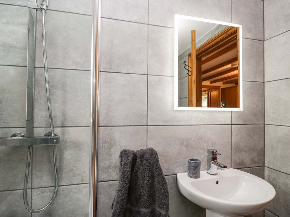 A bathroom with a sink and shower at Copper Beech Cottage in Torver