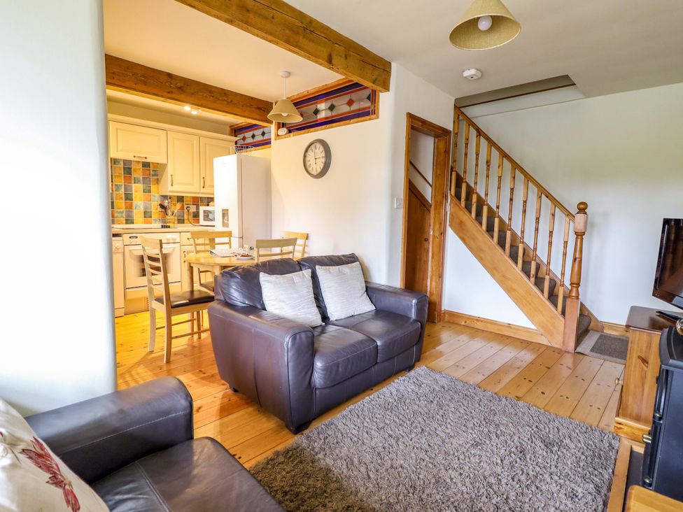 A living room with a sofa and dining area at Stabal Cottage in Dolgellau