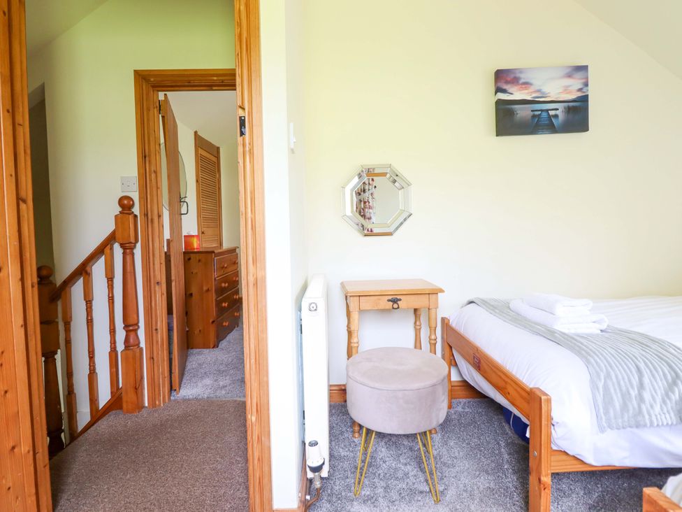 A bedroom with a bed and bedside table at Stabal Cottage in Dolgellau