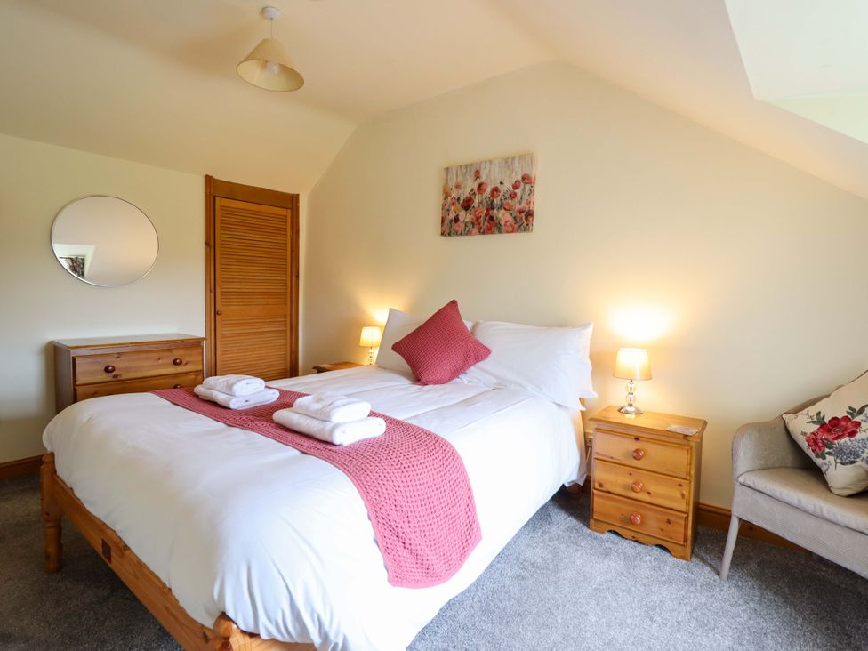 A bedroom with a bed and nightstand at Stabal Cottage in Dolgellau