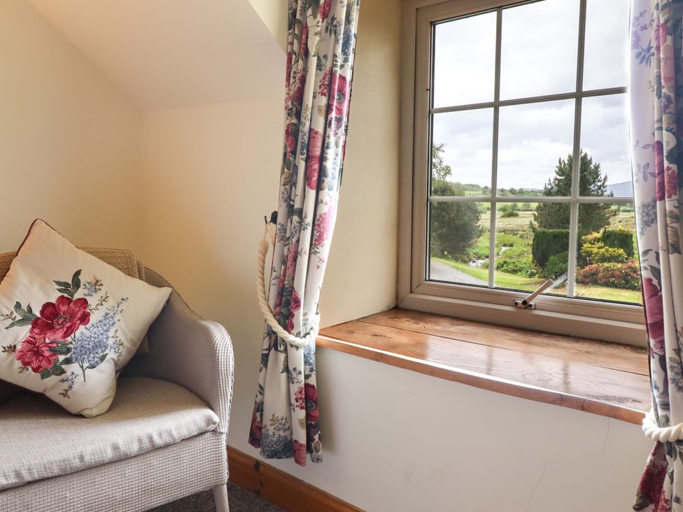 A snug with a chair and window at Stabal Cottage Dolgellau