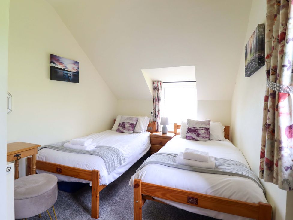 A bedroom with two beds and a window at Stabal Cottage in Dolgellau