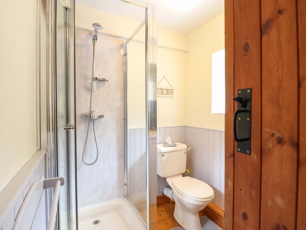 A bathroom with a shower, toilet, and sink at Stabal Cottage in Dolgellau