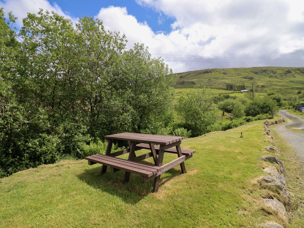A picnic table surrounded by grass and trees at Stabal Cottage in Dolgellau