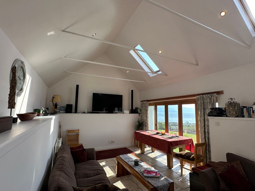 A living room with a sofa and large windows at Solas in Broadford