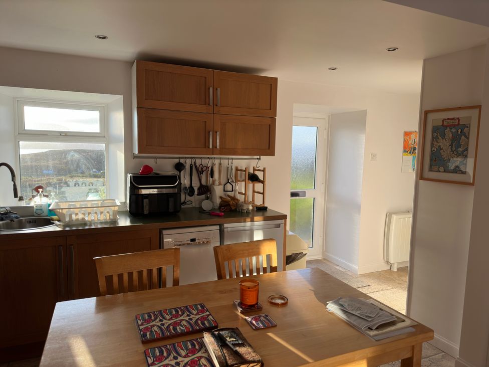 A kitchen with cabinets and a dining table at Solas in Broadford