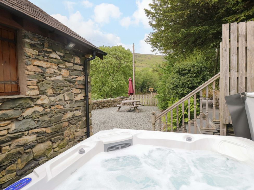 An outdoor area with a hot tub and a picnic table at Yew Tree Cottage Torver